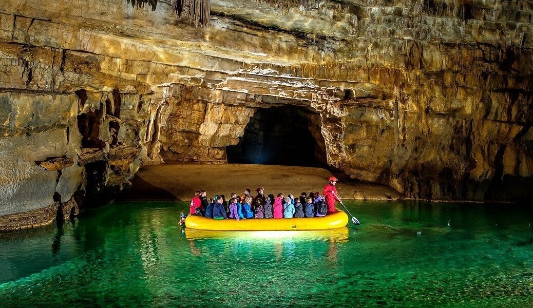 Entrance to Krizna Jama cave with visitors and rubber boats