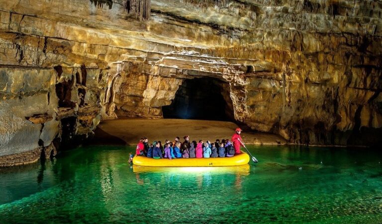 Entrance to Krizna Jama cave with visitors and rubber boats