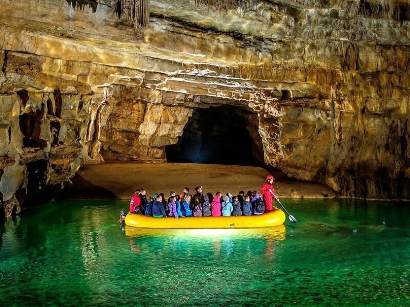 Entrance to Krizna Jama cave with visitors and rubber boats