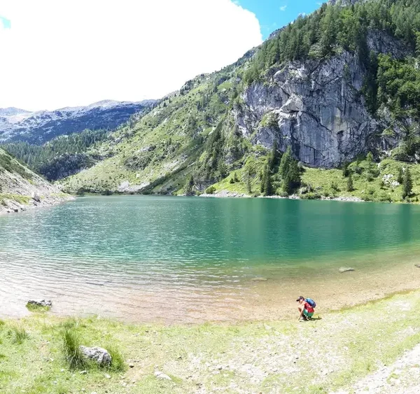 View of Lake Krsnko, a mountain lake surrounded by peaks, with clear water and rocky shore
